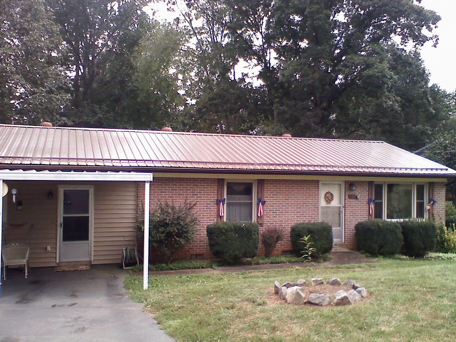 Bronze metal roof and carport on a brick ranch home — Roof Repair work by our crew in Sedalia