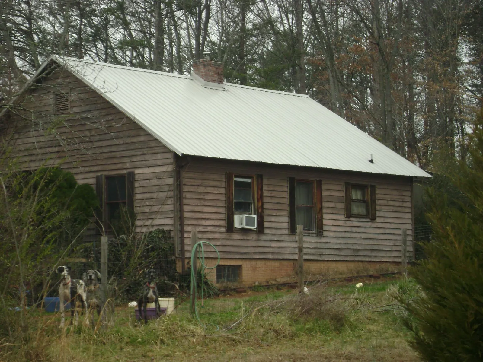 White metal roof on an old wood sided farmhouse, from a Metal Roof Installation job in Sedalia